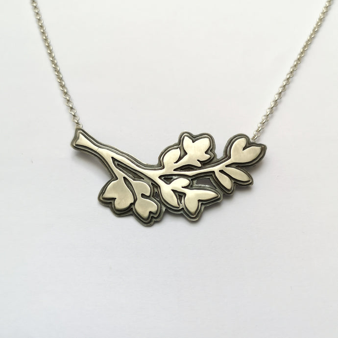 Penjoll ombra de flors i fulles de plata amb cadena de 40 cm
