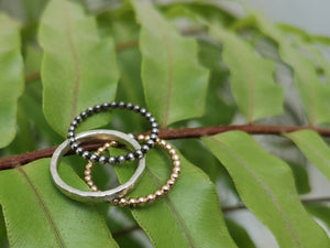 Tres anillos de bolas de oro y plata apilables, triplete de joyería mínima con plata oxidada y relleno de oro